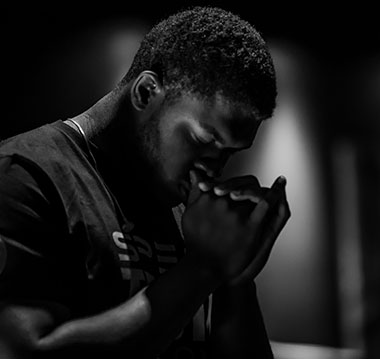 Black man praying - photo by Jack Sharp on Unsplash