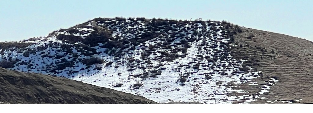 Hill with snow on one side and not on another side